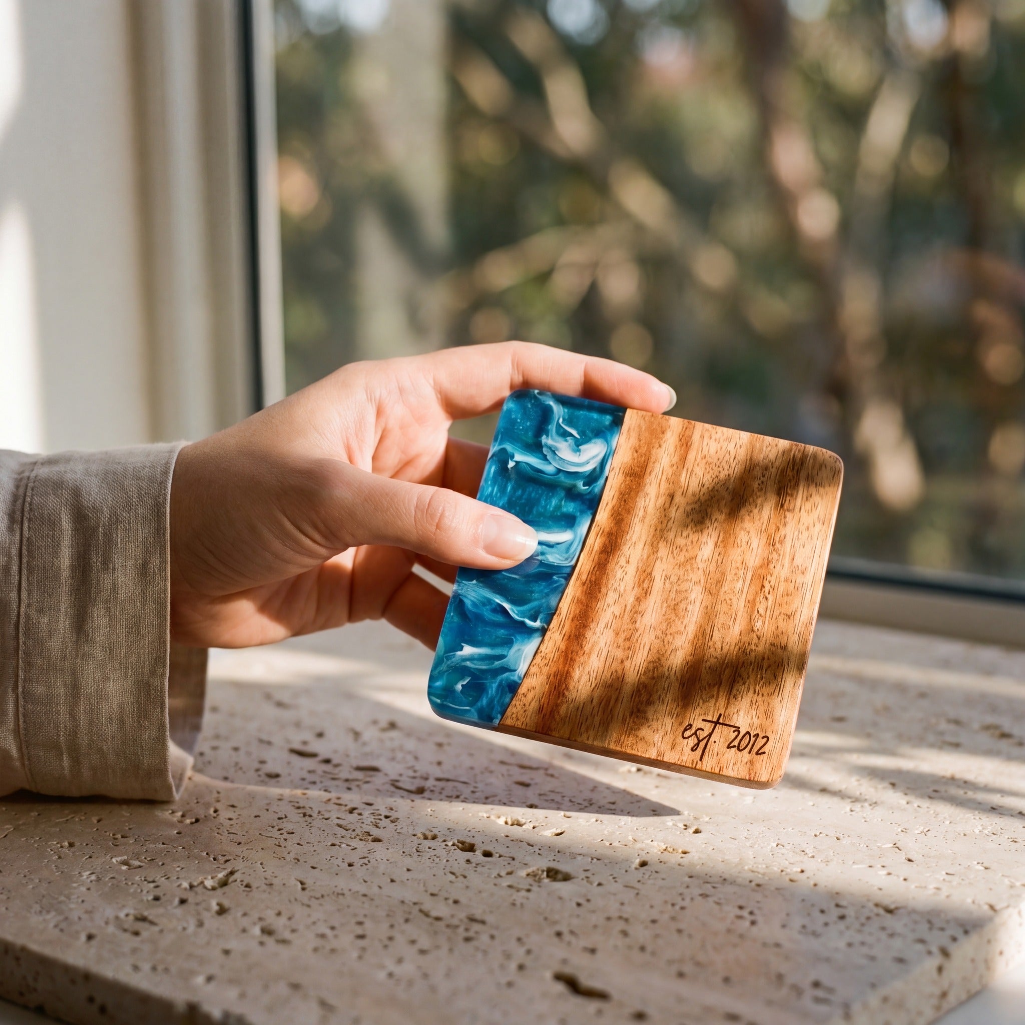 Seascape resin and wood coaster held in hand