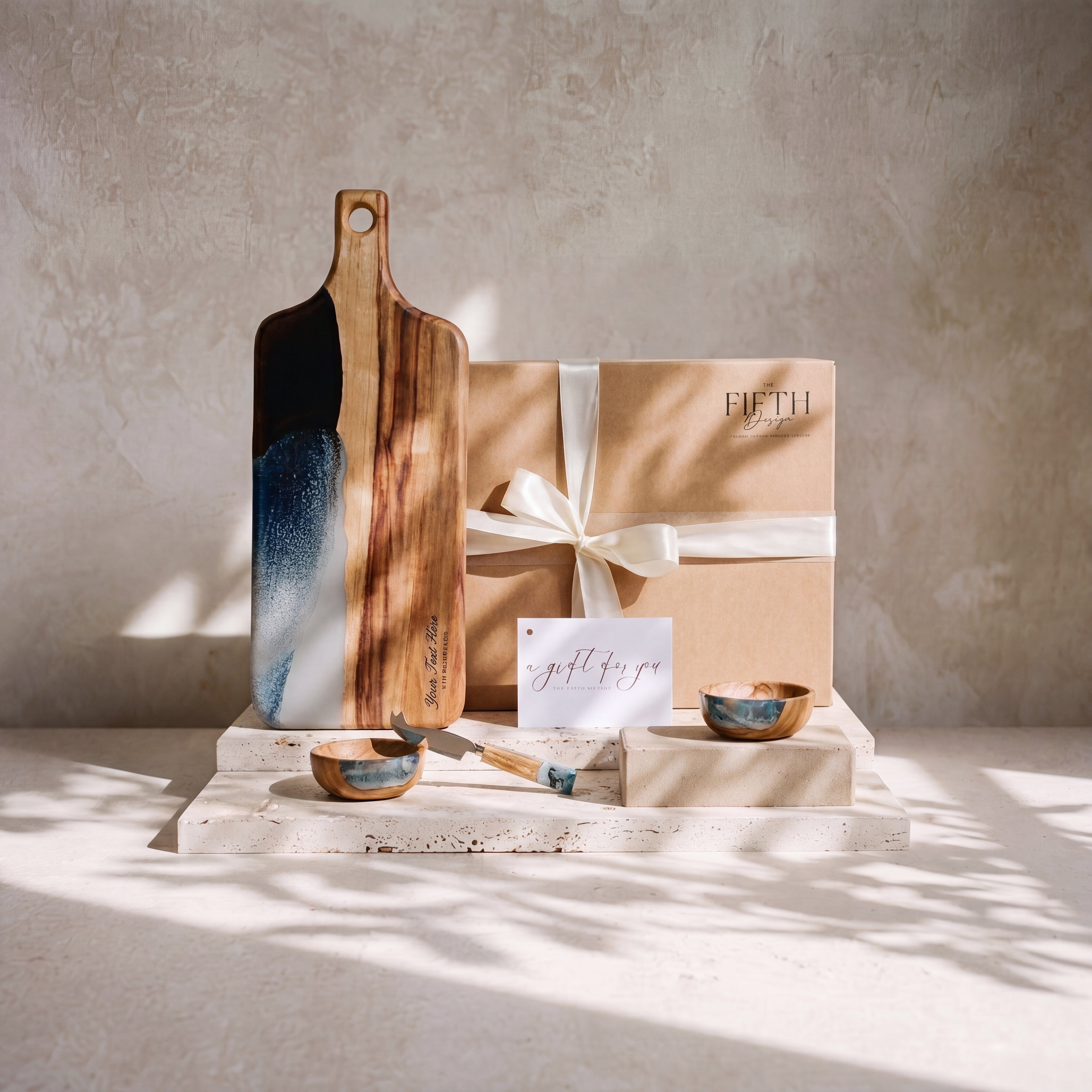 The Ultimate Gift Bundle in Slate - styled lifestyle hero, bundle arranged on travertine in warm editorial light