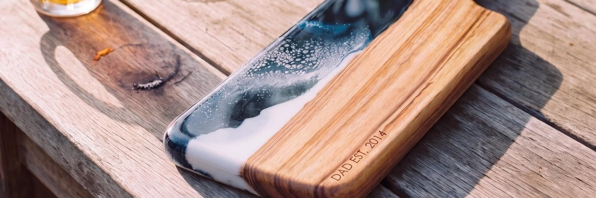 Camphor Laurel resin paddle engraved DAD EST. 2014 on an outdoor timber table