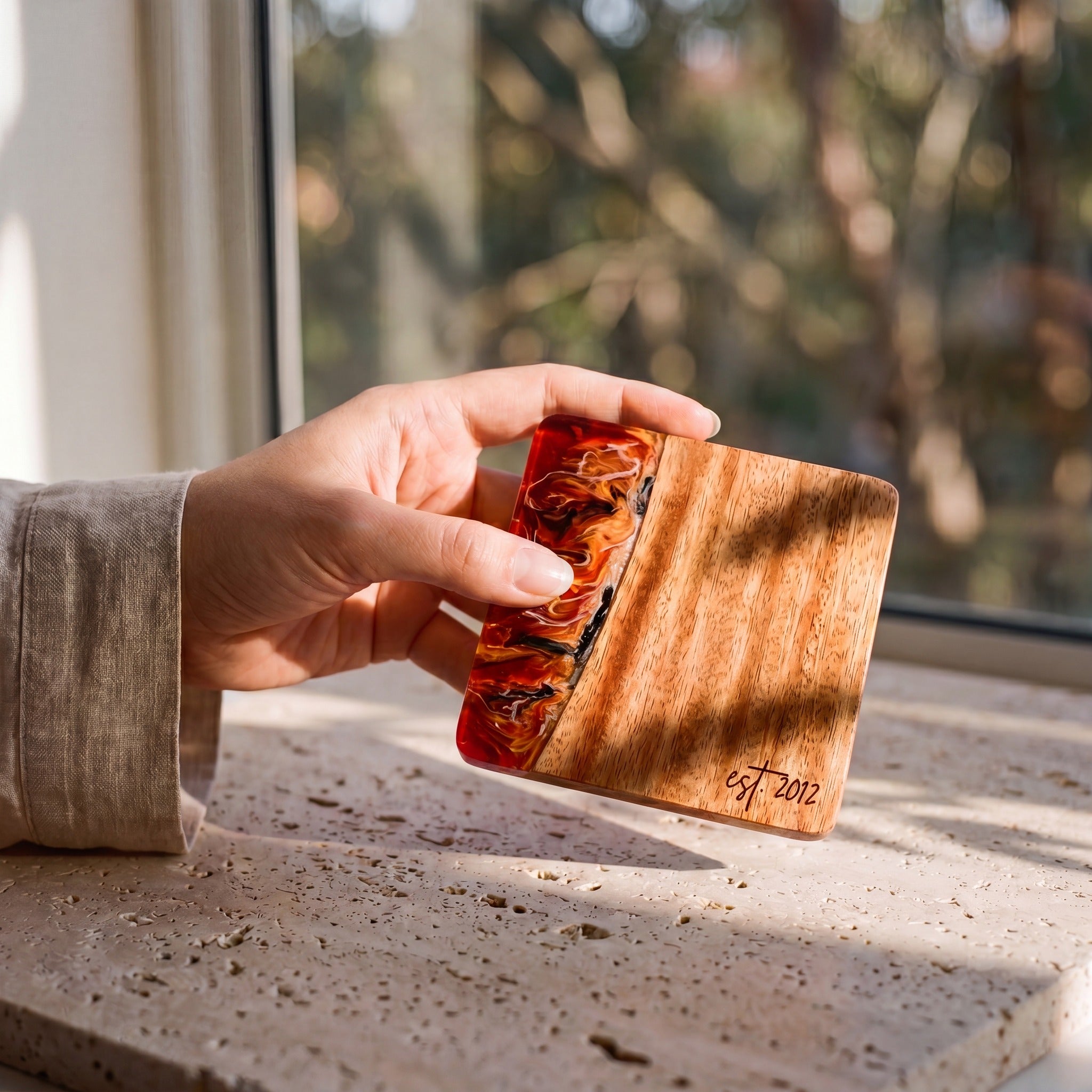 Burnt Ivory resin and wood coaster held in hand