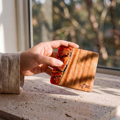Burnt Ivory resin and wood coaster held in hand