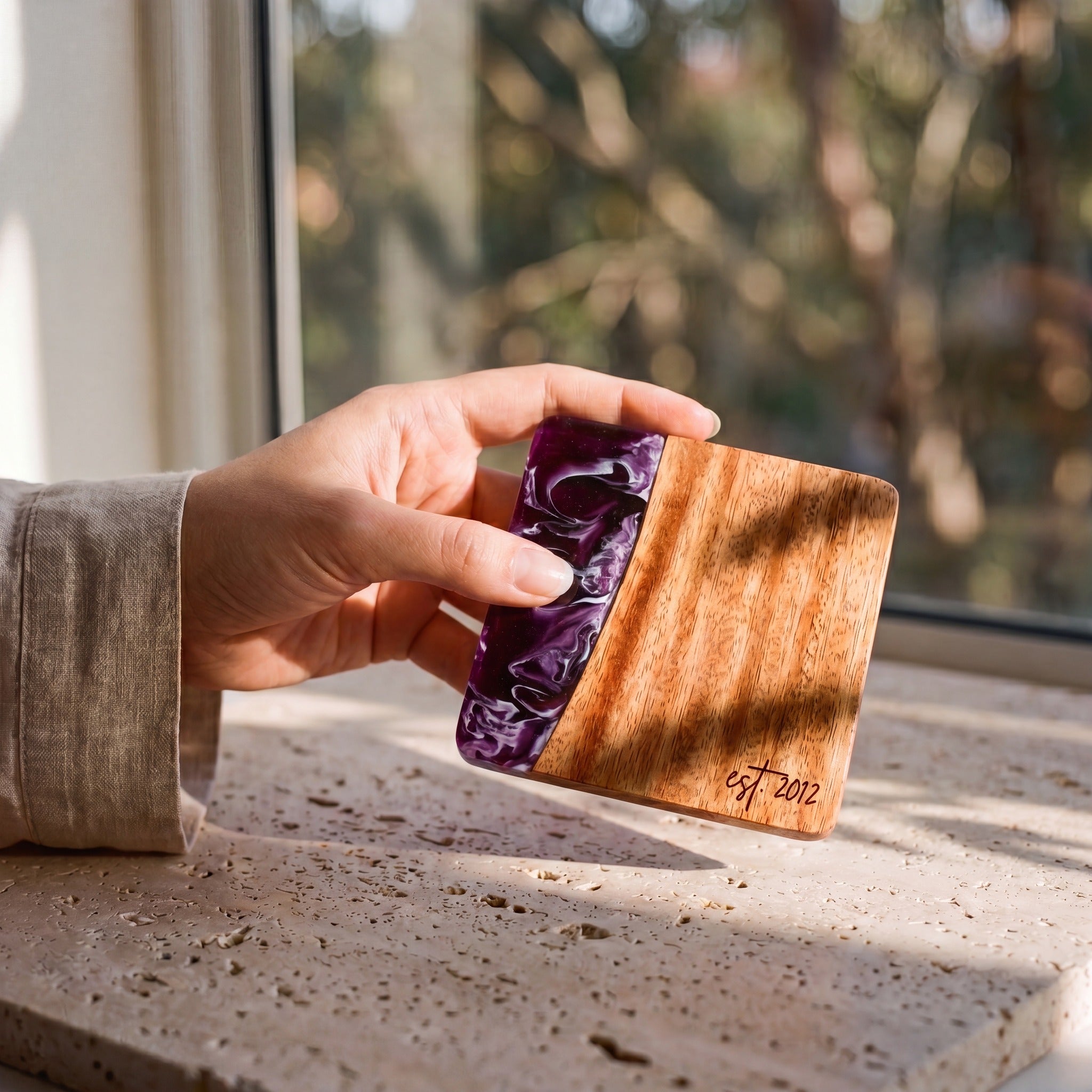 Lilac resin and wood coaster held in hand
