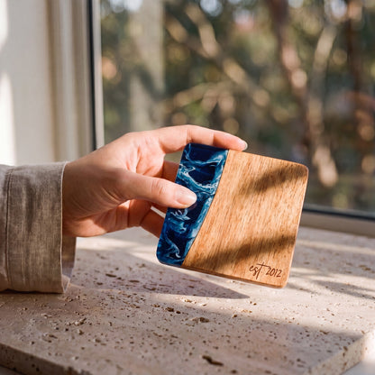 Prussian Blue resin and wood coaster held in hand